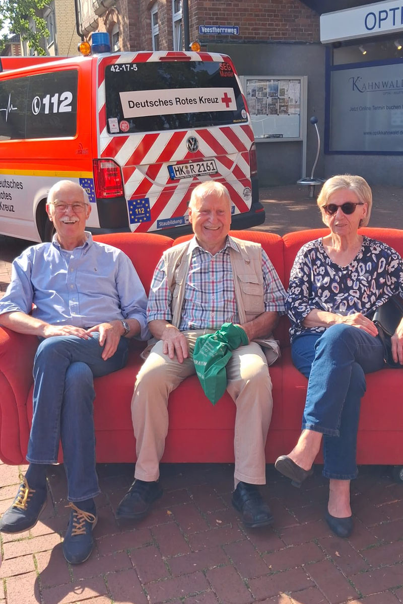 Drei Passanten auf dem roten Sofa